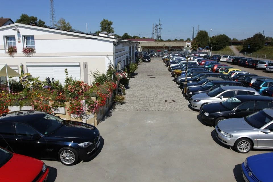Der Fahrzeughof der Albert Neumann GmbH mit zwei Reihen Gebrauchtwagen