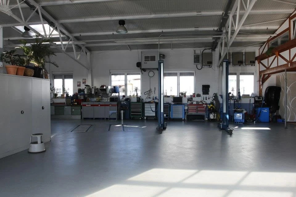 Blick in die Werkstatthalle mit zwei Hebebühnen und Werkzeugwagen